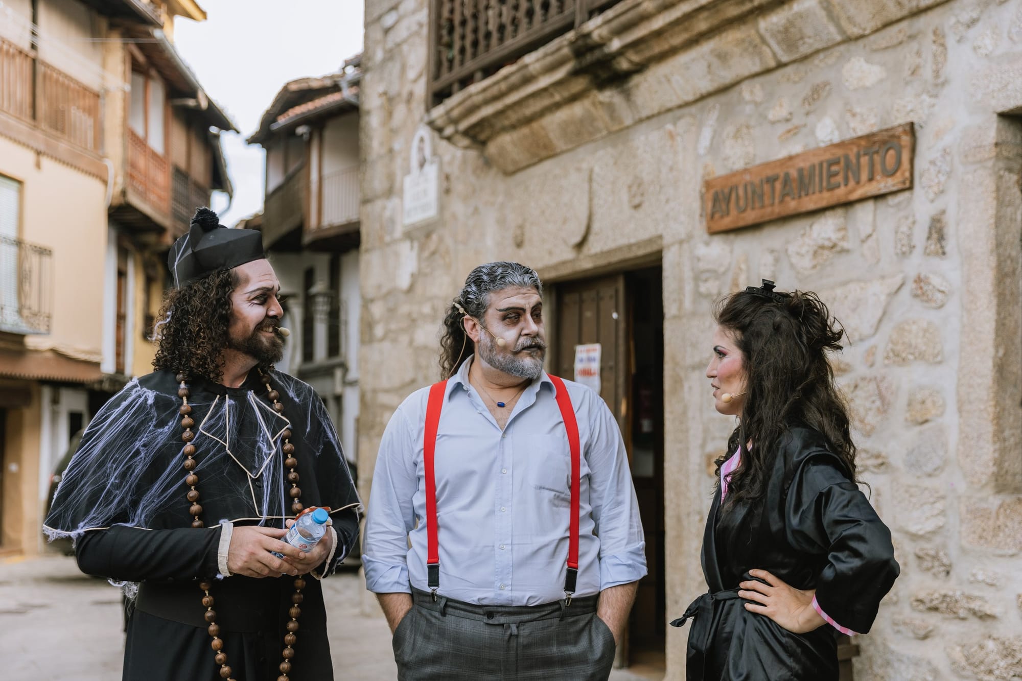 Integrantes de la producción conversan junto al ayuntamiento