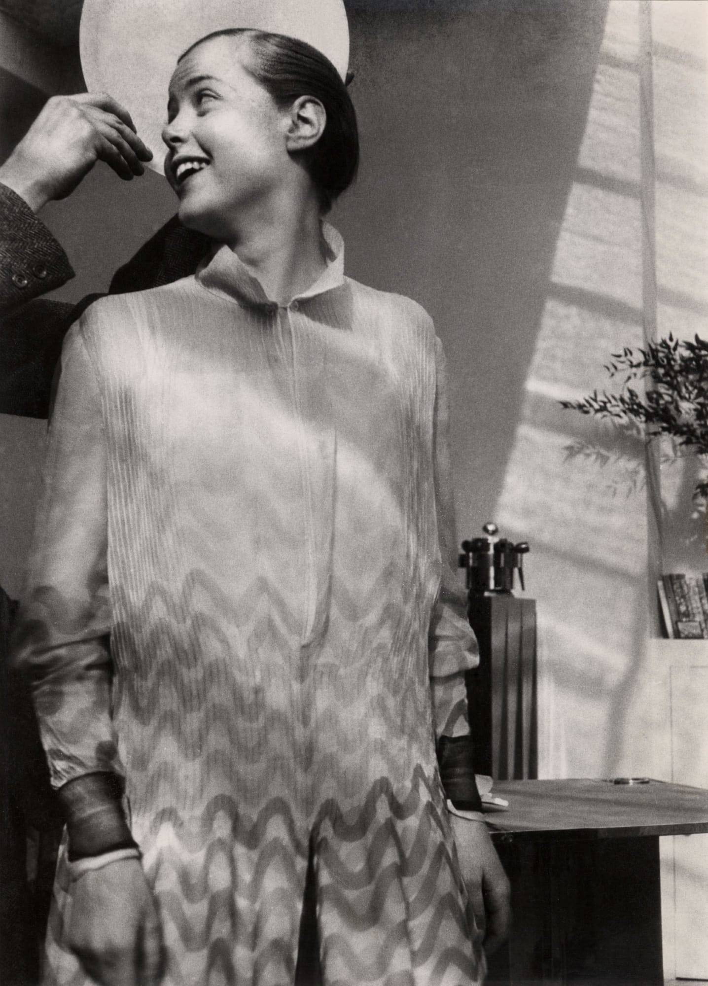 Retrato de Charlotte Perriand con un plato sostenido por Le Corbusier a modo de aureola