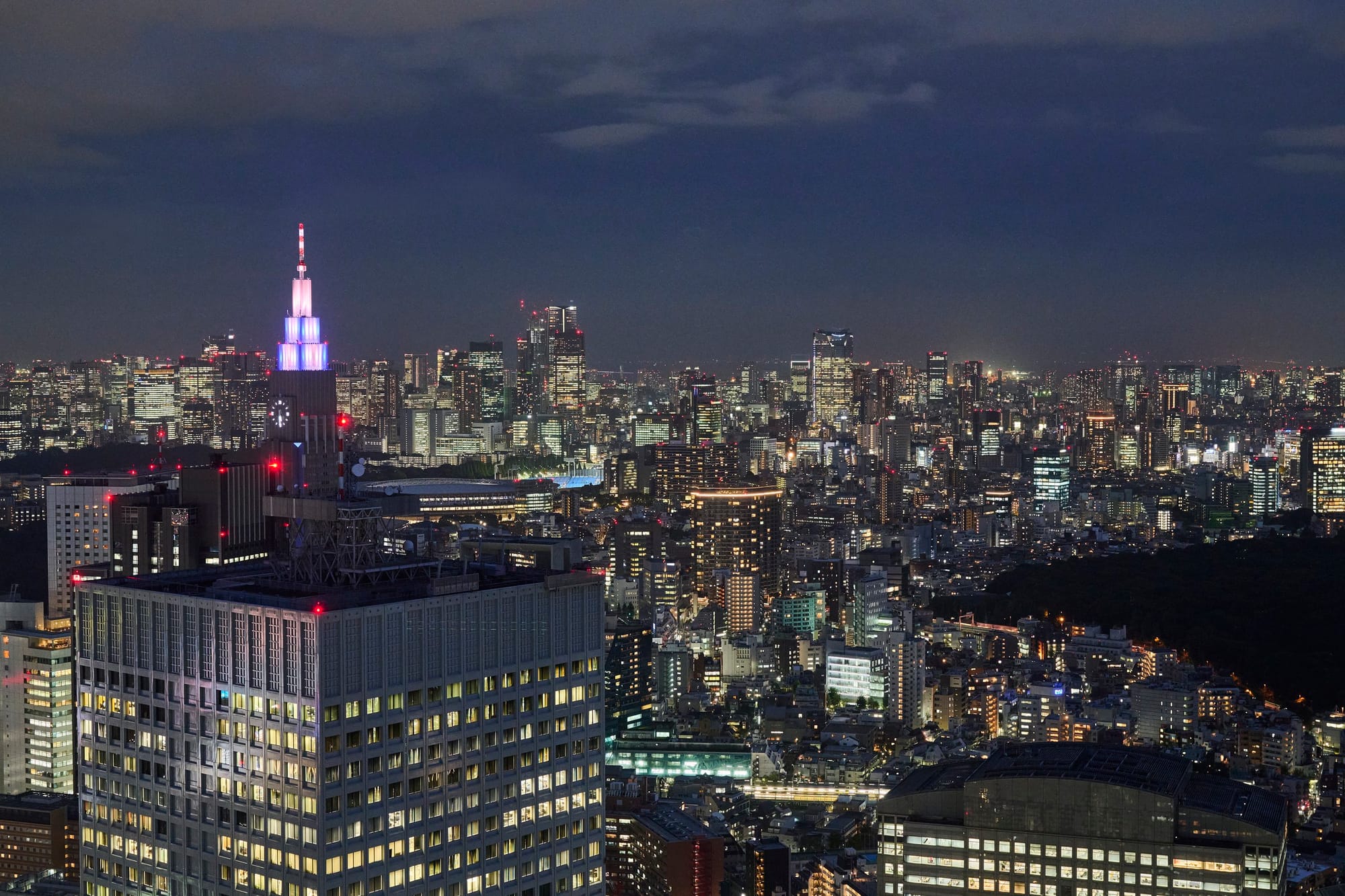 Rascacielos y luces de Tokio extendiéndose hacia el horizonte nocturno